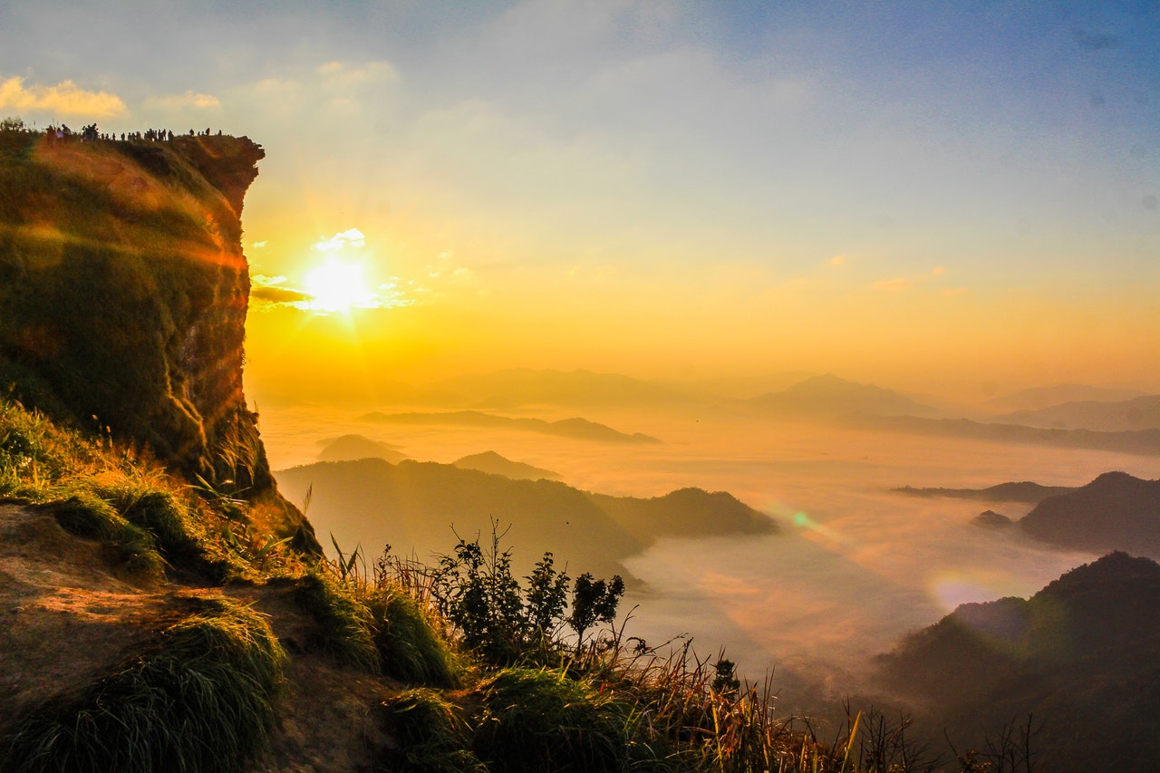 photo of a mountain surrounded by fog in the morning