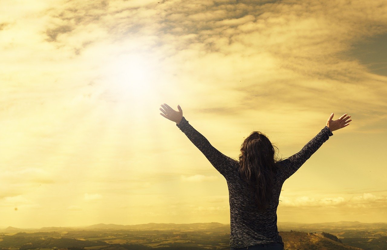 Woman looking to the heavens to find peace in times of trouble